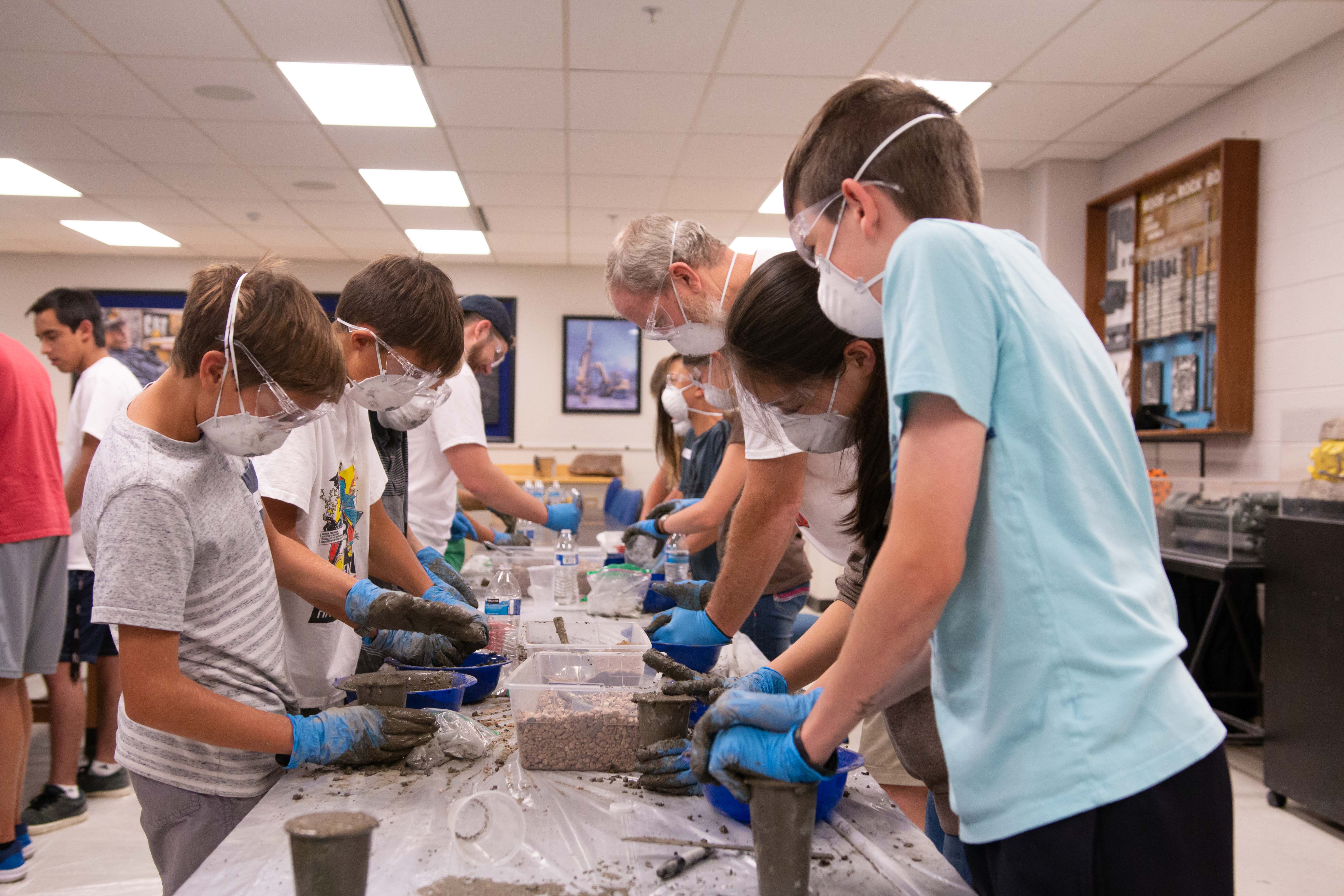 Students mix concrete at Tunnel Camp