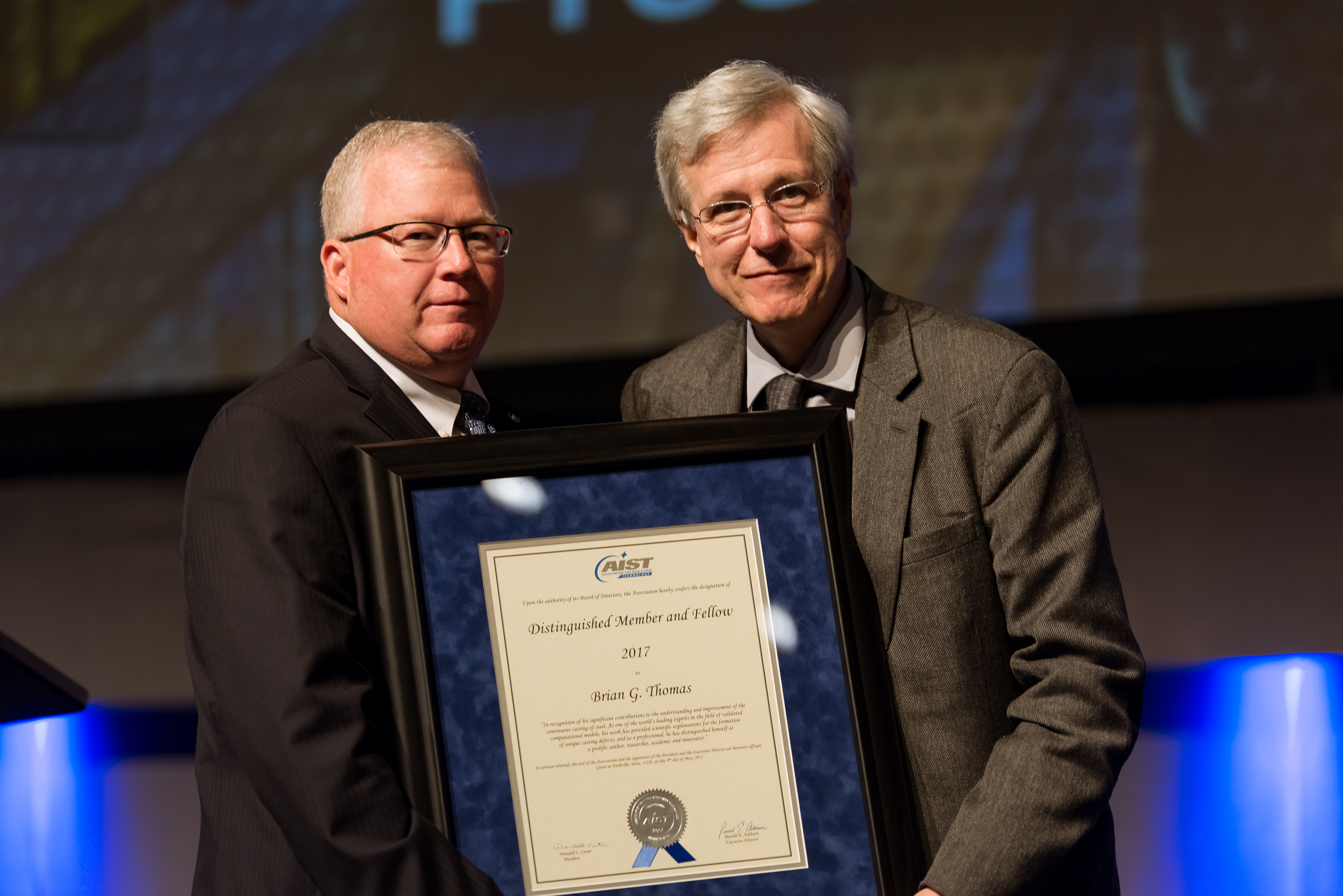 AIST Past President Wendell Carter, left, presents the Distinguished Member and Fellow Award to Brian Thomas.