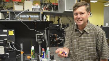 Chemical and biological engineering department head Dr. Dave Marr holds microbot models.