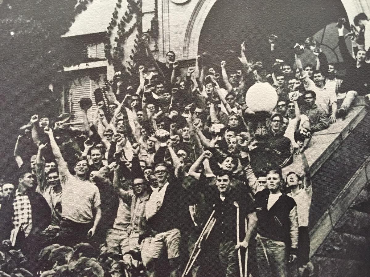 Black and white photo of the 1966 freshman class celebrating in front of one of the buildings on the Mines campus