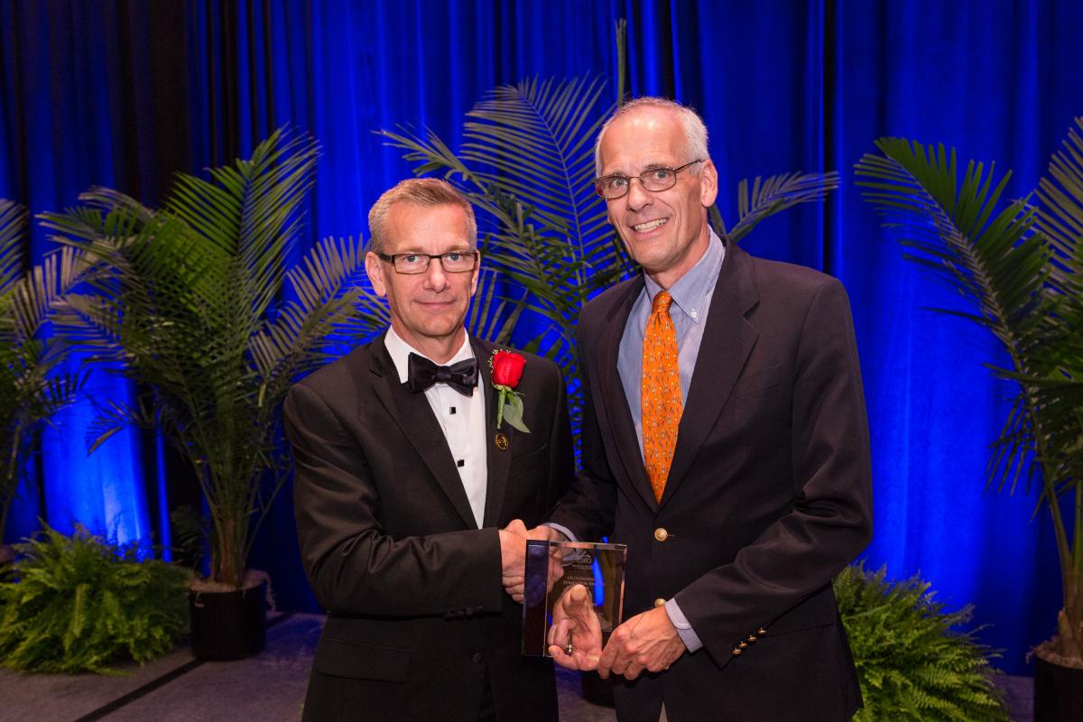 SEG President John Bradford presents Roel Snieder with the Outstanding Educator Award at the 2016 annual meeting in Dallas.