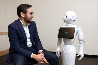 Assistant Professor Tom Williams with a robot