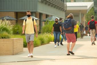 Masked students walk on pedestrian mall 