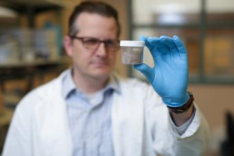 Chris Higgins holds a canister of PFAS