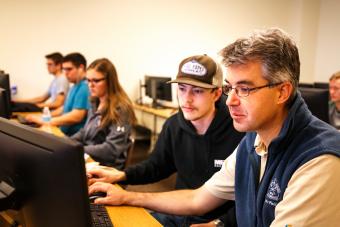 Paul Sava, right, works with a student during a Linux lab class