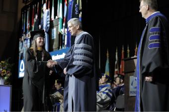 Rachael Lamman walks across stage at Commencement