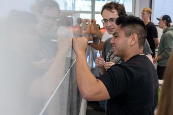 Students write on whiteboard