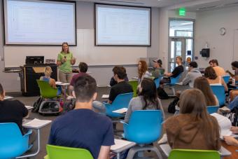 Female professor speaks to students in class