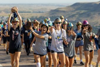 Female students carry rocks during M Climb