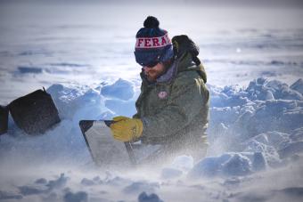 Matt Siegfried sitting with laptop in the snow