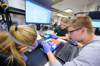 three students work together in biology class