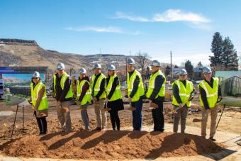 Mines officials scoop shovels of dirt at groundbreaking