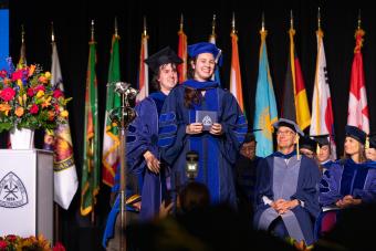 Female PhD student during hooding ceremony at Spring Commencement