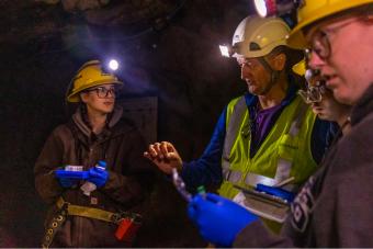 John Spear advises students during sample collection in cave