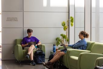 two students sitting in chairs in Marquez