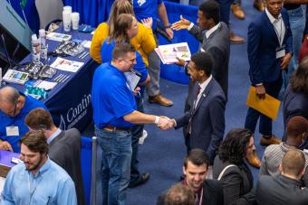 Mineral and Energy Economics master's student Abdallah El Badaoui shakes hands with a recruiter from Continental Resources.