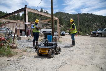 Students work with robot outside Edgar Mine