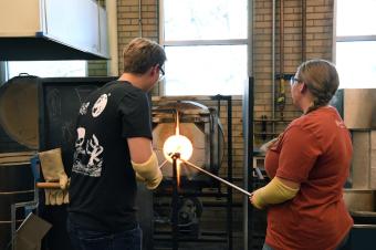 Two students work in the Hot Shop on the Mines campus