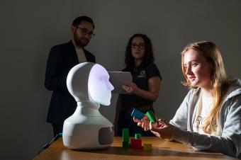 Female student interacts with robot in the lab