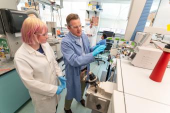 Chris Higgins and a student work in the lab