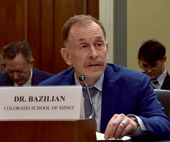 Morgan Bazilian speaking at a table