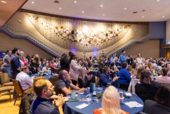 People standing and applauding in campus event hall