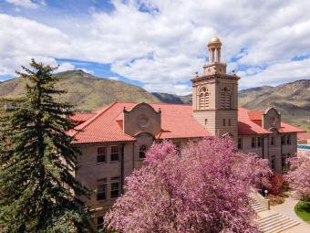 Guggenheim Hall with blooming trees against backdrop of Mount Zion and blue sky