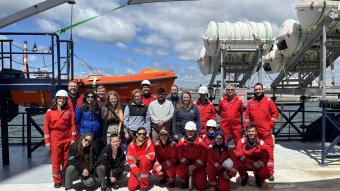 group photo of scientists in red aboard boat