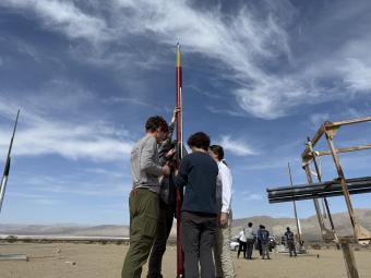 group of students working on rocket with desert in background