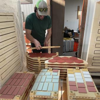 Chris Caskey loads red and green tile into kiln