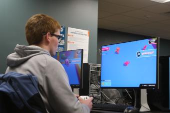 male student plays computer game in esports lab
