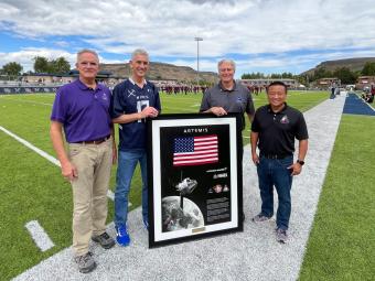 President Johnson, Paul Anderson and others pose with Orion artifacts on football field