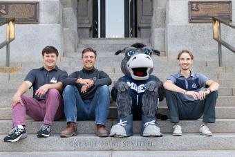 three mines students sit on the state capitol steps with blaster