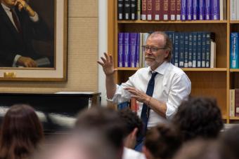 george saunders talks in front of library books