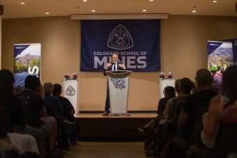 george saunders speaks at podium in front of audience
