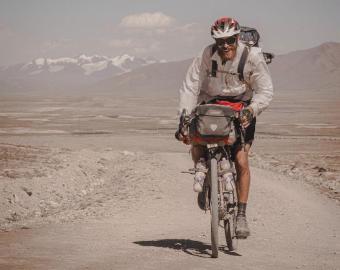 Peter Consalvi riding a bike in a desert