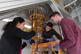 A faculty member and two students work on a dilution refrigerator in a quantum lab on the Mines campus