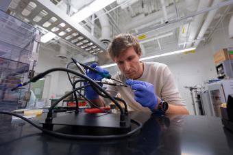Wouter Van De Pontseele wears blue gloves while assembling wiring on some equipment 