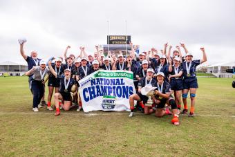 team shot of mines women's rugby team with championship banner