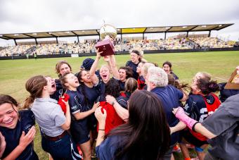 mines rugby team celebrating with trophy