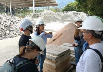 students in hardhats tour sustainable construction facility in Colombia
