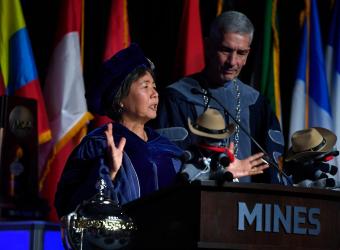 stefanie tompkins in regalia speaks at commencement podium