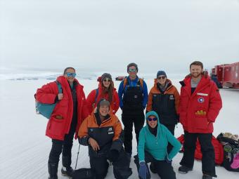 group of scientists pose for photo in antarctica