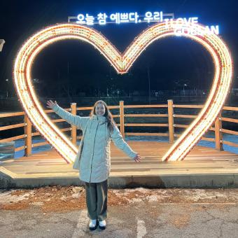 student poses in front of heart shaped light in korea