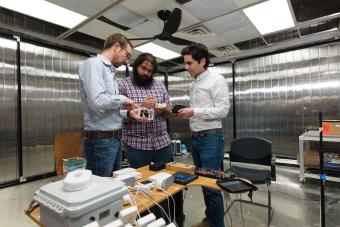 Paulo Cesar Tabares Velasco and graduate students Andy Gloor and Quin Guy inspect an indoor air quality data acquisition system in the AMBER Lab at Mines