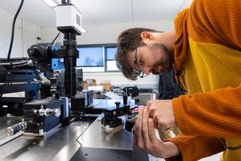 male student works on photonic chip