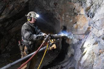 student drills into mine wall at Edgar Mine
