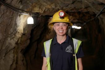 Elizabeth Holley in a yellow hard hat inside a mine