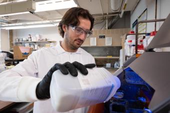 PhD student loads a piece of lab equipment for an experiment