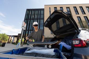 Patrick Miko unloads his skateboard and belongings during move-in day at Lookout Apartments.